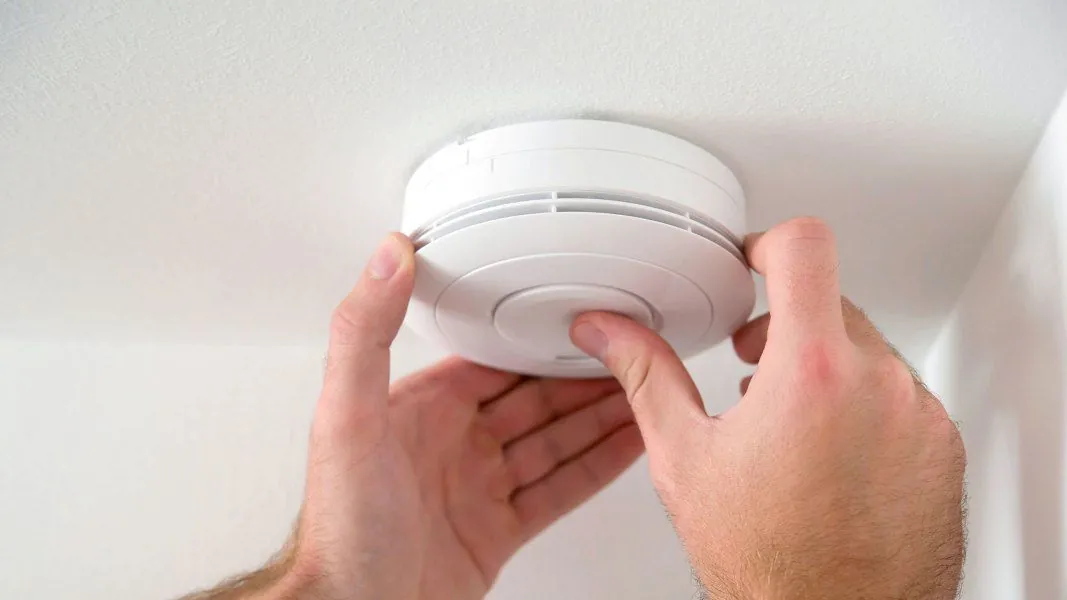 Alarmanlage wird von einem Mitarbeiter an der Decke angebracht